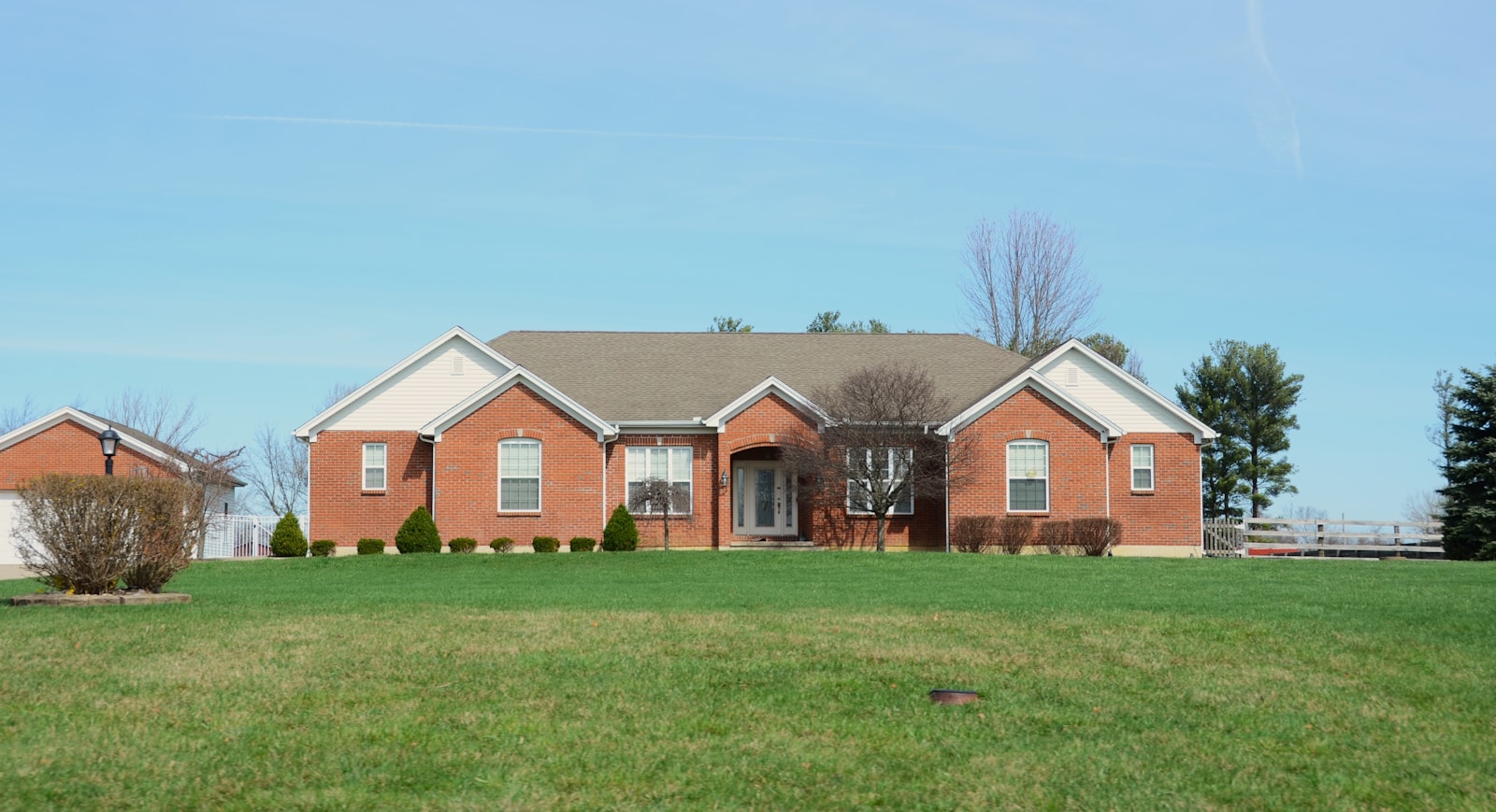 Brick suburban home with a freshly mowed and edged front lawn.